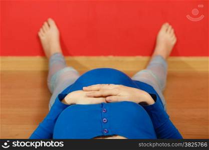 Pregnancy, motherhood and happiness concept. Pregnant woman lying on floor relaxing.
