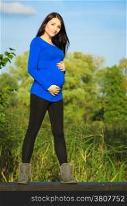 Pregnancy, motherhood and happiness concept. young happy pregnant woman walking relaxing and enjoying life in nature