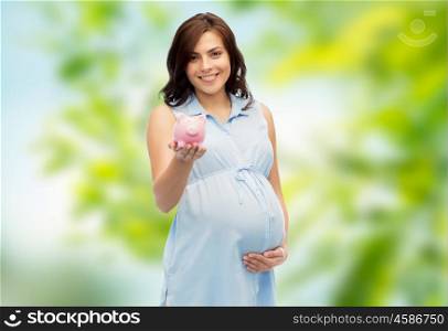 pregnancy, motherhood, finance, saving and people concept - happy pregnant woman with piggybank over green natural background