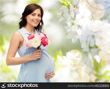 pregnancy, motherhood, holidays, people and expectation concept - happy pregnant woman with flowers touching her big belly over natural spring cherry blossom background. happy pregnant woman with flowers touching belly
