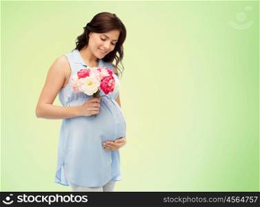 pregnancy, motherhood, holidays, people and expectation concept - happy pregnant woman with flowers touching her big belly over green natural background