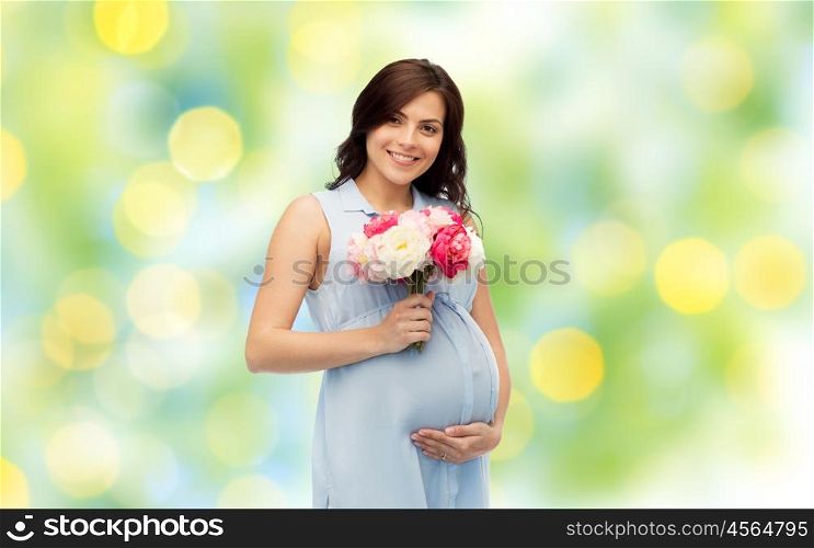 pregnancy, motherhood, holidays, people and expectation concept - happy pregnant woman with flowers touching her big belly over green holidays lights background