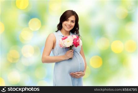 pregnancy, motherhood, holidays, people and expectation concept - happy pregnant woman with flowers touching her big belly over green holidays lights background