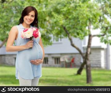 pregnancy, motherhood, holidays, people and expectation concept - happy pregnant woman with flowers touching her big belly over summer garden and house background