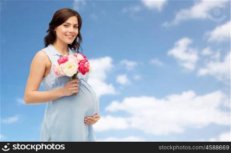 pregnancy, motherhood, holidays, people and expectation concept - happy pregnant woman with flowers touching her big belly over blue sky background