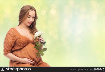 pregnancy, motherhood, holidays, people and expectation concept - happy pregnant woman with rose flower over summer green lights background. happy pregnant woman with white rose flower