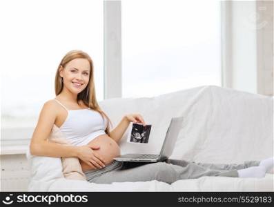 pregnancy, motherhood, medicine, health, internet and technology concept - smiling pregnant woman with laptop and ultrasound picture