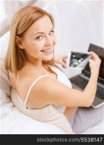 pregnancy, motherhood, medicine, health, internet and technology concept - smiling pregnant woman with laptop and ultrasound picture