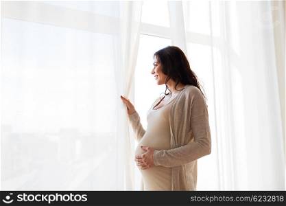 pregnancy, motherhood, people and expectation concept - close up of happy pregnant woman with big belly looking to window