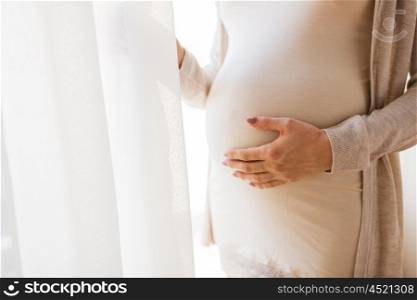 pregnancy, motherhood, people and expectation concept - close up of pregnant woman belly and hands