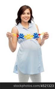 pregnancy, motherhood, people and expectation concept - happy pregnant woman holding rattle toy over white background