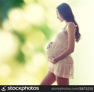 pregnancy, motherhood, people and expectation concept - happy pregnant woman in chemise over green background