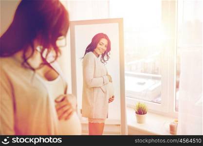 pregnancy, motherhood, people and expectation concept - happy pregnant woman looking to mirror at home