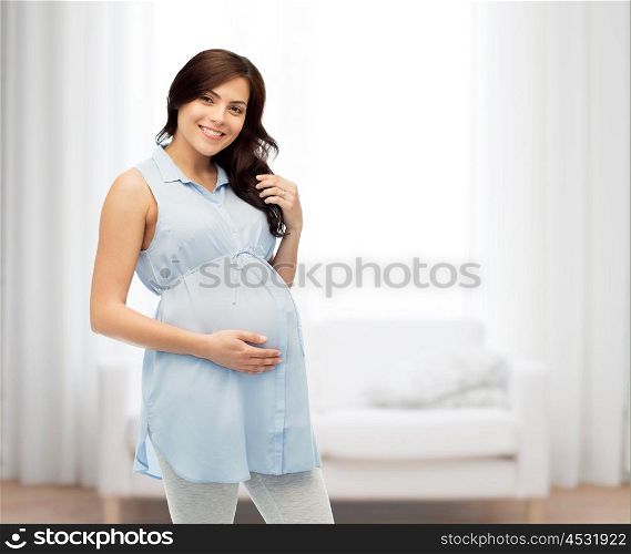 pregnancy, motherhood, people and expectation concept - happy pregnant woman touching her big belly over home living room background