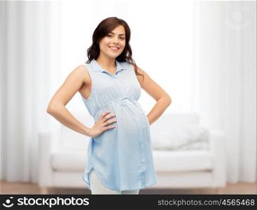 pregnancy, motherhood, people and expectation concept - happy pregnant woman touching her big belly over home room background