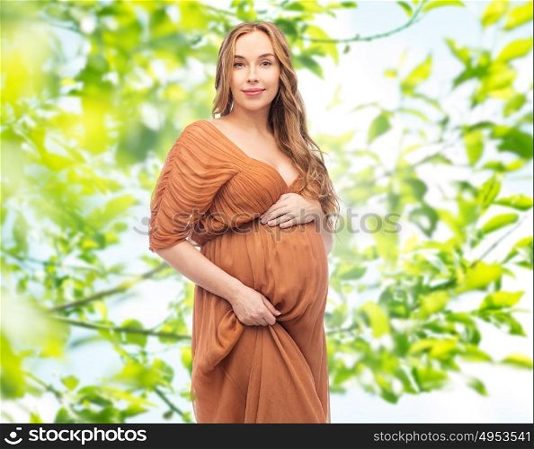 pregnancy, motherhood, people and expectation concept - happy pregnant woman touching her big belly over summer green leaves background. happy pregnant woman over summer green background