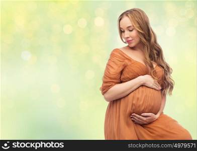 pregnancy, motherhood, people and expectation concept - happy pregnant woman touching her big belly over summer green lights background. happy pregnant woman touching her big belly