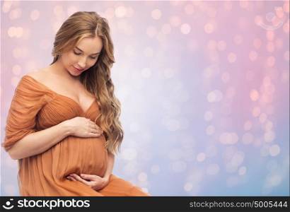 pregnancy, motherhood, people and expectation concept - happy pregnant woman touching her big belly over rose quartz and serenity background with lights. happy pregnant woman touching her big belly