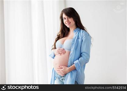 pregnancy, motherhood, people and expectation concept - happy pregnant woman with big bare tummy at home. happy pregnant woman with big tummy at home