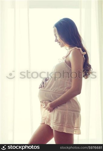 pregnancy, motherhood, people and expectation concept - happy pregnant woman with big bare tummy at home