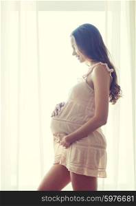 pregnancy, motherhood, people and expectation concept - happy pregnant woman with big bare tummy at home