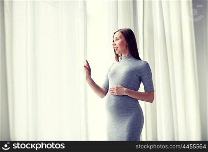 pregnancy, motherhood, people and expectation concept - happy pregnant woman with big tummy at home
