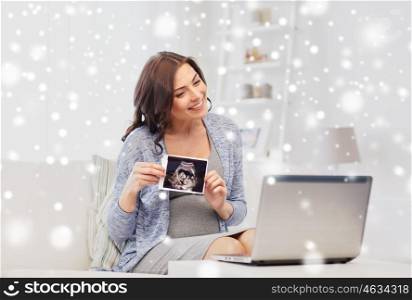 pregnancy, motherhood, people and expectation concept - happy pregnant woman with laptop computer having video call and showing ultrasound image at home over snow