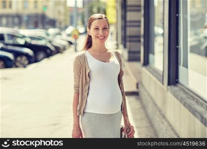 pregnancy, motherhood, people and expectation concept - happy smiling pregnant woman at city street