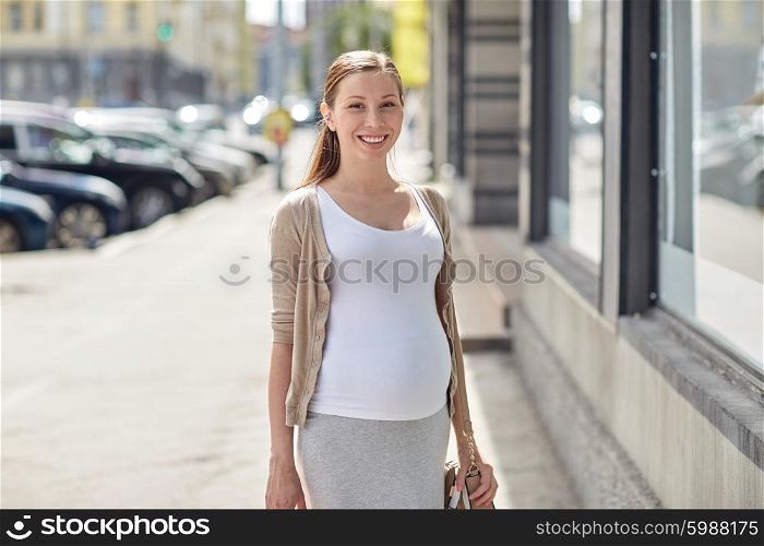 pregnancy, motherhood, people and expectation concept - happy smiling pregnant woman at city street