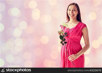 pregnancy, motherhood, people, holidays and expectation concept - happy pregnant woman with white rose flower over pink holidays lights background