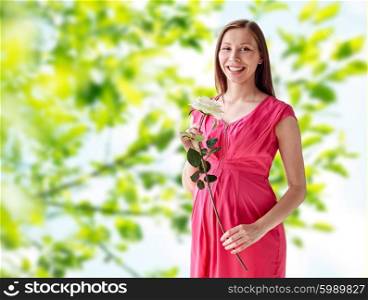 pregnancy, motherhood, people, holidays and expectation concept - happy pregnant woman with white rose flower over green natural background