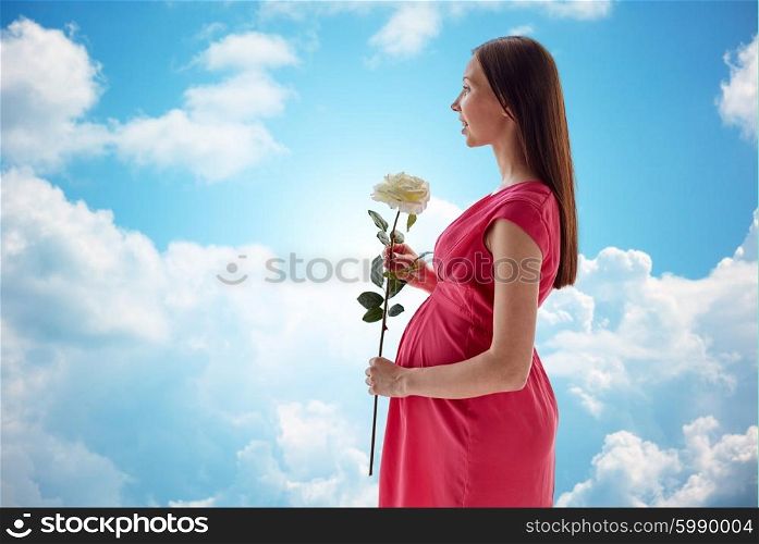 pregnancy, motherhood, people, holidays and expectation concept - happy pregnant woman with white rose flower over blue sky and clouds background
