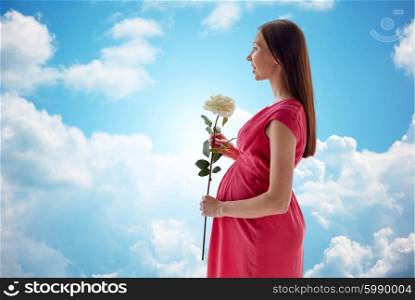 pregnancy, motherhood, people, holidays and expectation concept - happy pregnant woman with white rose flower over blue sky and clouds background