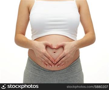pregnancy, motherhood, people, love and expectation concept - close up of happy pregnant woman making heart shape hand sign over her bare tummy