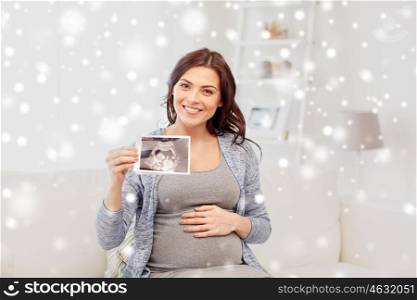 pregnancy, motherhood, people, winter and medicine concept - happy pregnant woman holding at ultrasound image at home over snow