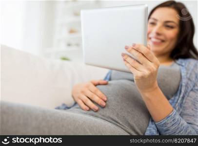 pregnancy, motherhood, technology, people and expectation concept - close up of happy pregnant woman with tablet pc computer at home