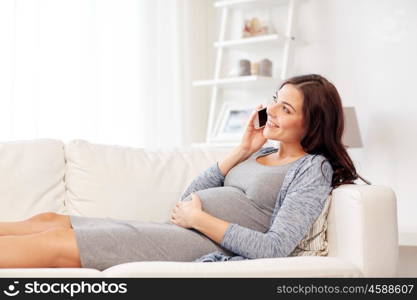 pregnancy, motherhood, technology, people and expectation concept - happy pregnant woman calling on smartphone at home