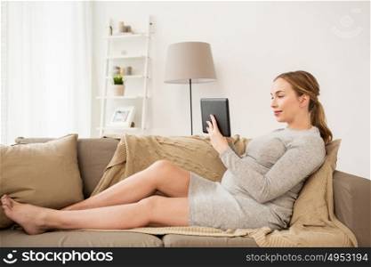 pregnancy, motherhood, technology, people and expectation concept - happy pregnant woman with tablet pc computer at home. happy pregnant woman with tablet pc at home