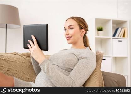 pregnancy, motherhood, technology, people and expectation concept - happy pregnant woman with tablet pc computer at home. happy pregnant woman with tablet pc at home