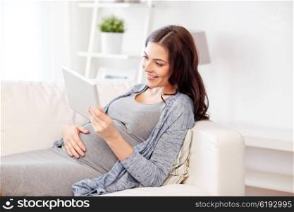 pregnancy, motherhood, technology, people and expectation concept - happy pregnant woman with tablet pc computer at home