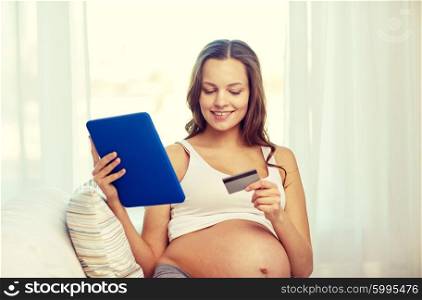 pregnancy, online shopping, technology and people concept - happy pregnant woman with tablet pc computer and credit card at home