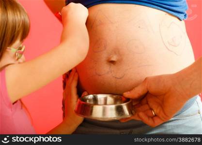 Pregnancy, parenthood and happiness concept. Family expecting new baby, having fun, drawing painting cat face on belly of pregnant woman