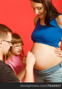 Pregnancy, parenthood and happiness concept. Family expecting new baby, having fun, drawing painting on belly of pregnant woman