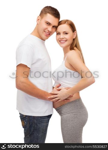pregnancy, parenthood and happiness concept - happy young family expecting child