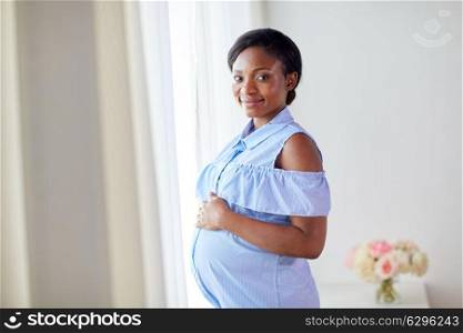 pregnancy, people and expectation concept - happy pregnant african american woman at home. pregnant african american woman at home