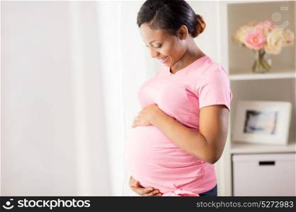 pregnancy, people and expectation concept - happy pregnant african american woman with big belly at home. happy pregnant woman with big belly at home