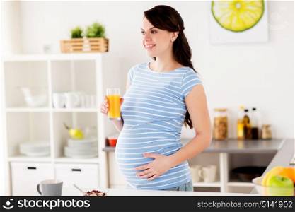 pregnancy, people and healthy eating concept - happy pregnant woman with glass of orange juice and muesli having breakfast at home kitchen. happy pregnant woman having breakfast at home
