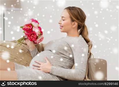 pregnancy, people and holidays concept - happy pregnant woman with flowers at home over snow. happy pregnant woman with flowers at home
