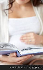 pregnancy, people and motherhood concept - close up of pregnant woman reading book