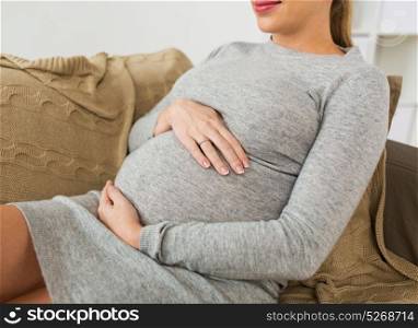 pregnancy, people and motherhood concept - close up of pregnant woman with big belly at home. close up of pregnant woman with big belly